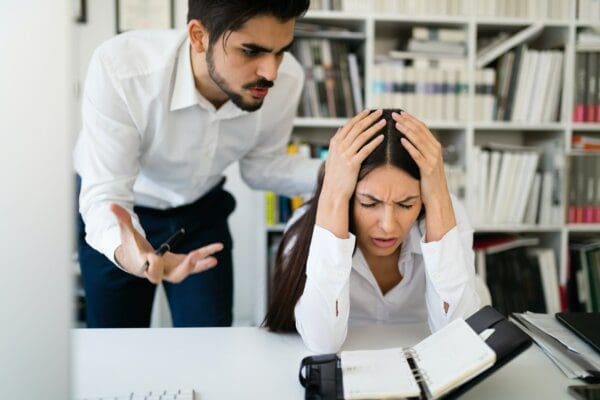 Angry boss and his employee in office represents workplace conflict