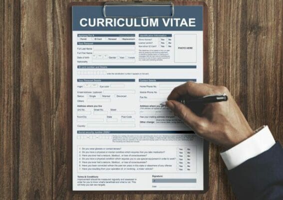 Close-up of a one page CV Curriculum Vitae with the hand of the interviewer writing with a pen