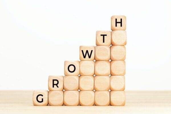 Growth spelled with wooden blocks forming a rising formation
