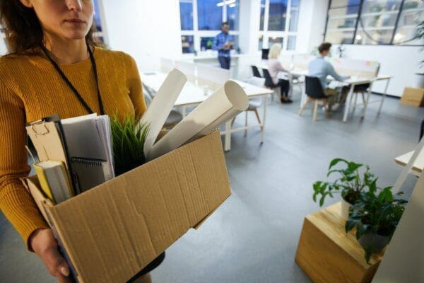Female employee leaving office with box of belongings