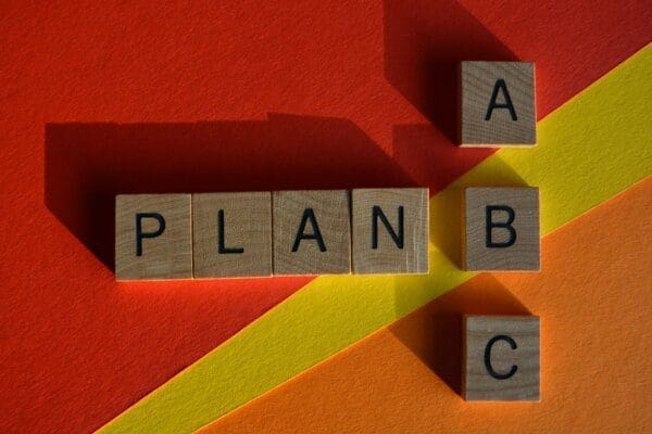 Plan A, Plan B, or Plan C written with wooden blocks on orange and yellow background