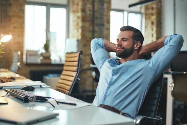 Satisfied businessman leaning back with hands behind his head 
