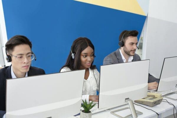 Focused call center operators with headsets working in front of computers
