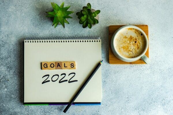Goals 2022 written on a notepad with coffee next to it