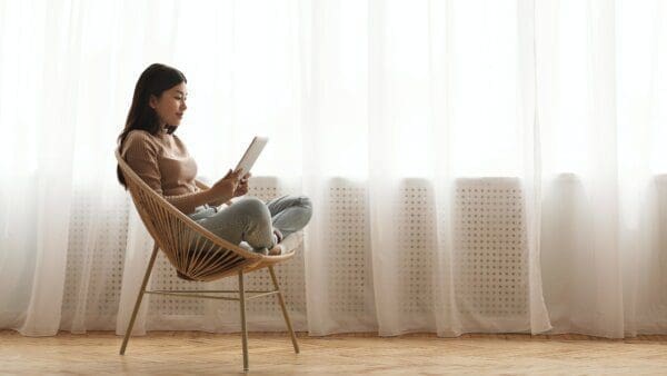 Girl reading a book in a chair in the morning 