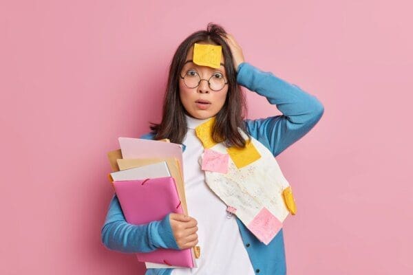 Puzzled shocked female office worker overloaded with paper information