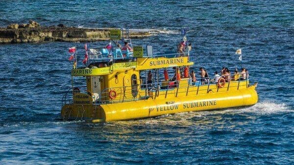 A yellow submarine on top of the water with people aboard