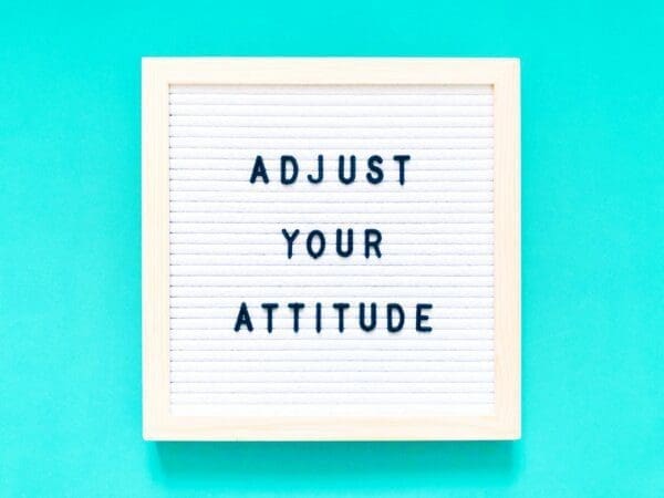 Adjust your attitude quote on a felt board on blue background