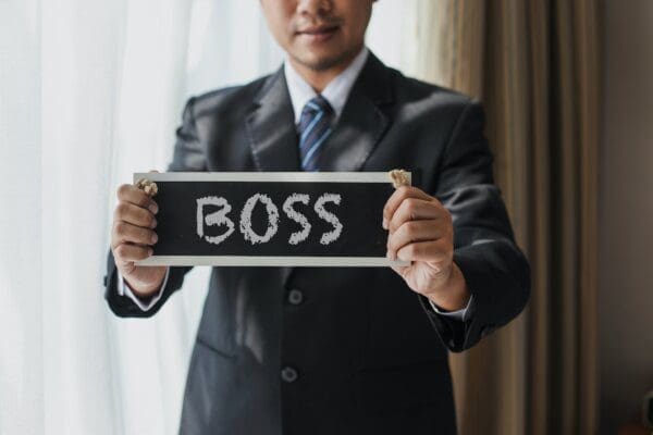Businessman holding up a boss sign