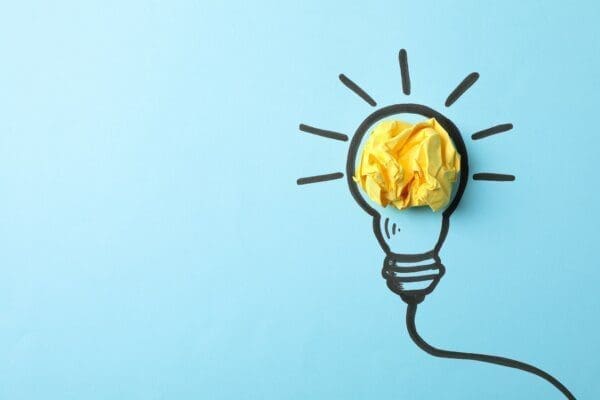 Bulb drawing on blue background with yellow scrunched paper