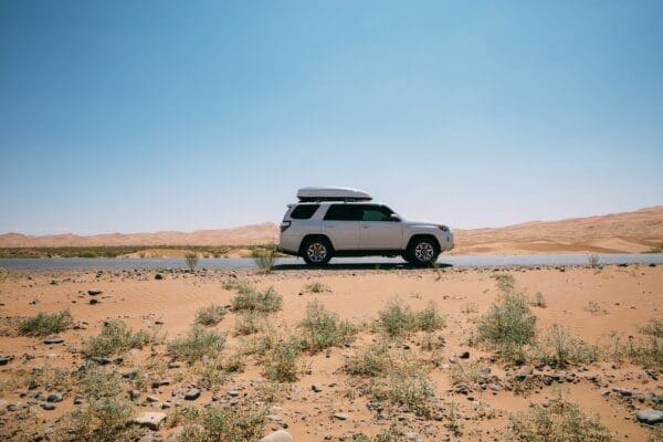 White Toyota car driving across the desert 