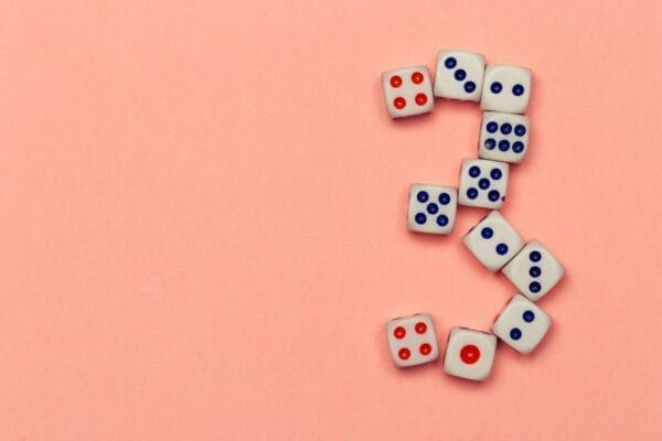 Number three made of dice on peachy background 
