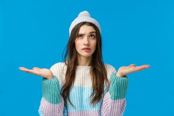 infp Girl in sweater weighing up options with her hands up with a thinking expression