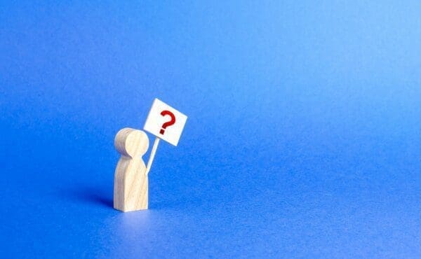 A person figurine with a question mark sign on a blue background