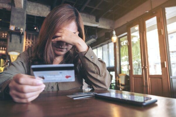 A woman holding credit card with feeling stressed and broke