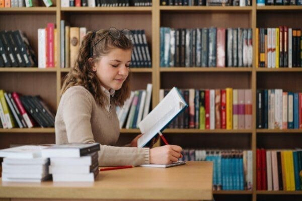 entp Girl studying among books sitting at the desk among books
