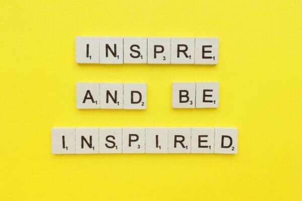 Inspire and be inspired quote on yellow background