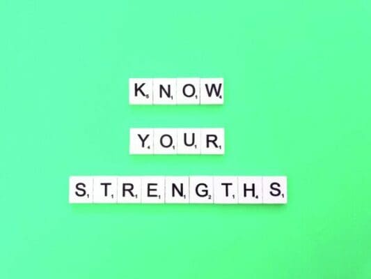Know your strengths quote in scrabble tiles on green background