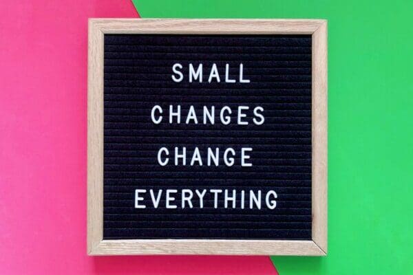 Small changes change everything quote on pink and green background