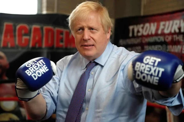 Boris Johnson wearing boxing gloves that say 'Get Brexit Done' for the three word persuasion technique