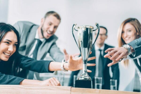 close-up shot of businesspeople trying to take champion cup
