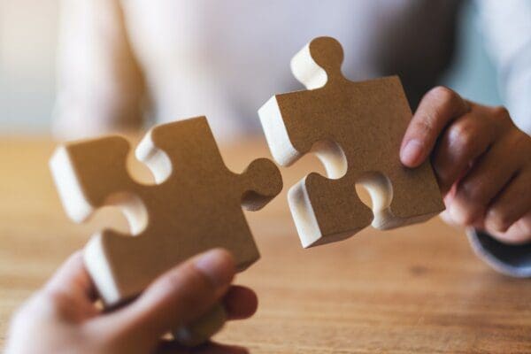 Two soulmates holding and putting a piece of a puzzle together