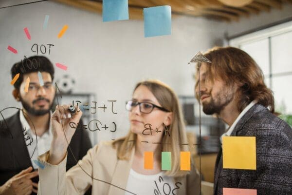 Intelligent ENFJ entrepreneurs brainstorming new plan on an office glass board