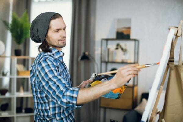ISFP Man drawing with brush on canvas at art studio