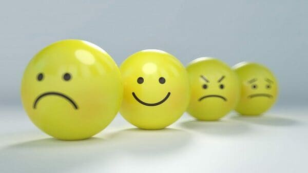 Four yellow balls with emotions sad, happy, mad, and worried