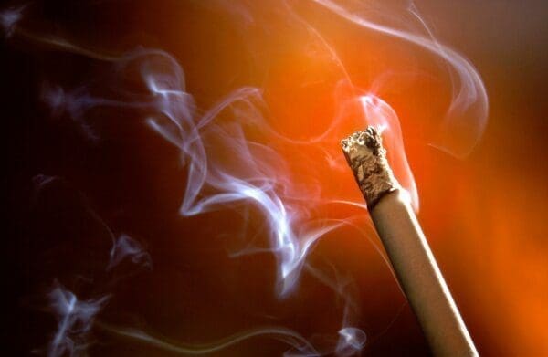 Close up of a cigarette with smoke coming off it