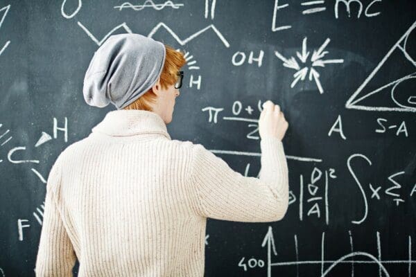 Male INTP student writing equations on a blackboard
