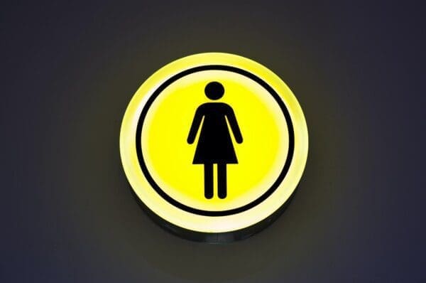 Yellow female sign on dark surface