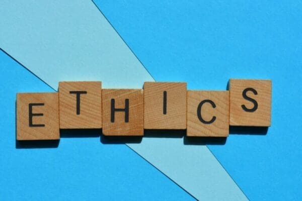 Ethics spelled with wooden alphabet blocks in blue background