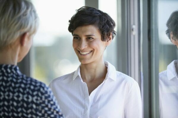 Smiling businesswoman using a persuasion technique during conversation to get people to do what you want