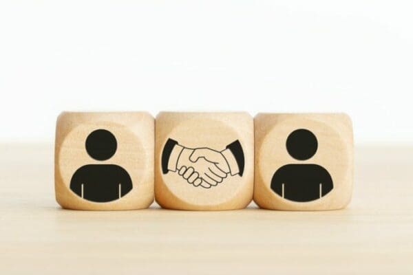 ISTJ and INTJ wooden figure blocks with a handshake between them represent common ground