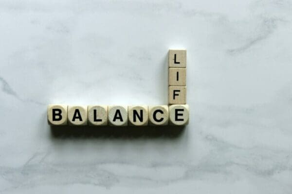 Life Balance spelled with wooden cubes on a white marble surface