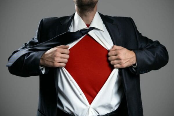 Businessman tearing his shirt open to show a superhero costume