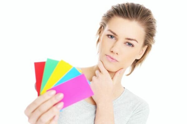 Lady holding colourful cards which represents strategic leadership styles