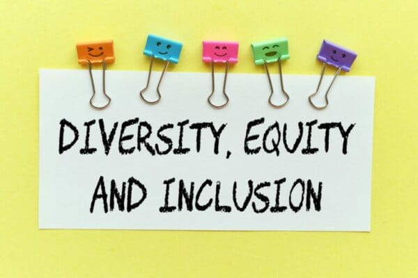 Diversity, Equity and Inclusion on a white note with colourful paper clips