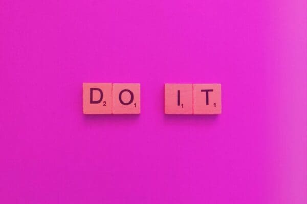 Do it spelled with wooden cubes on pink background