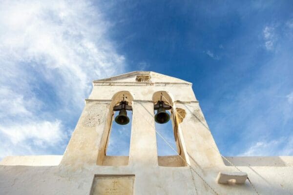 Large wedding bells on a old church bell tower at low angle view