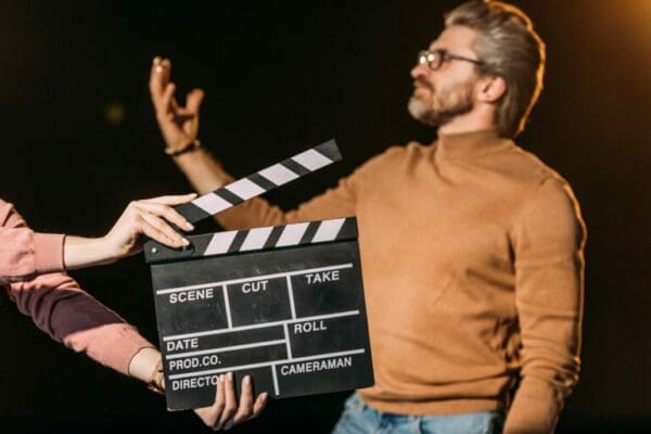 Male ESTJ actor performing with clapboard in front