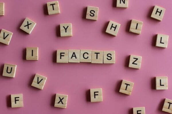FACTS spelt with wooden cubes on pink background