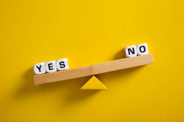 Yes vs No balance scales on yellow background