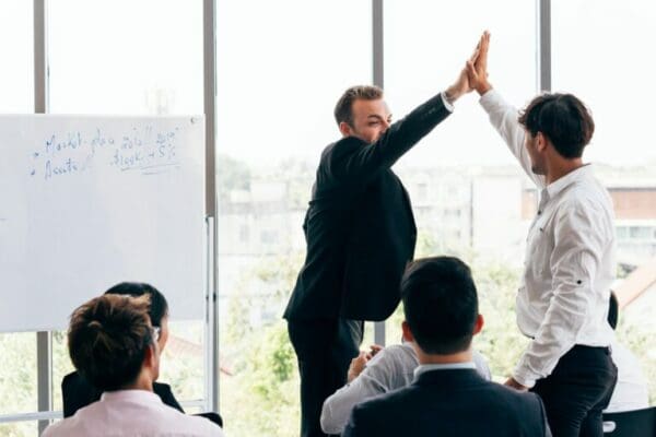 HR manager giving high five to employee during conference