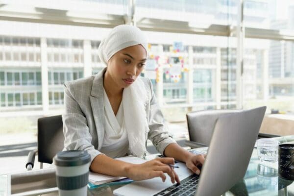 Businesswoman in hijab researching The big 5 personality traits on her laptop