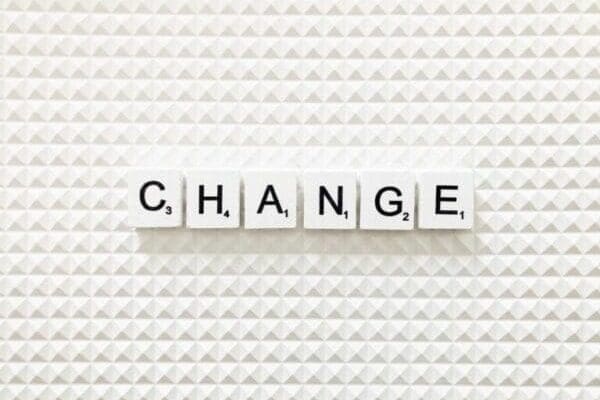 Change spelled with white letterblocks on lego pattern surface
