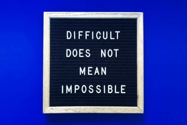 Difficult does not mean impossible quote with blue background