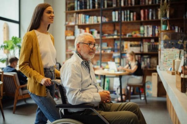 Female ESTJ guardian helping older male in a wheelchair