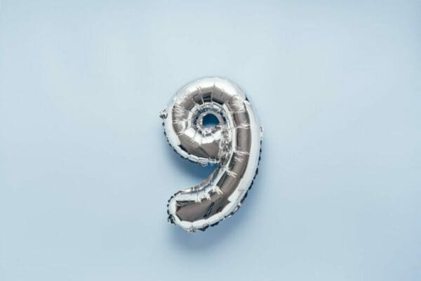 Silver number 9 balloon on light blue background